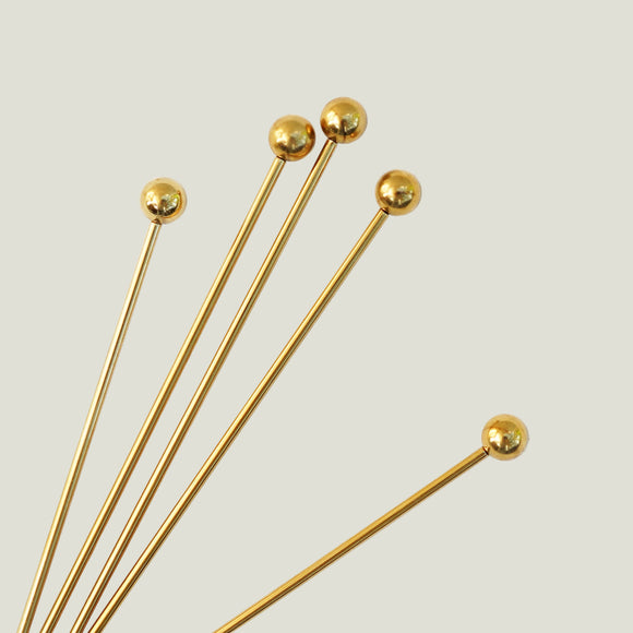 Gold headpins on a white background