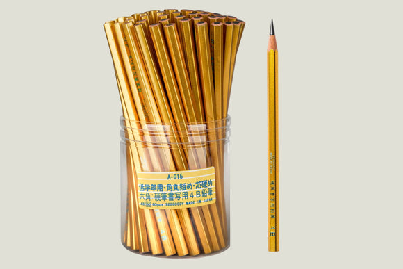 Gold pencils in a cylindrical container with one pencil leaning against it on a white background