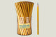 Gold pencils in a cylindrical container with one pencil leaning against it on a white background