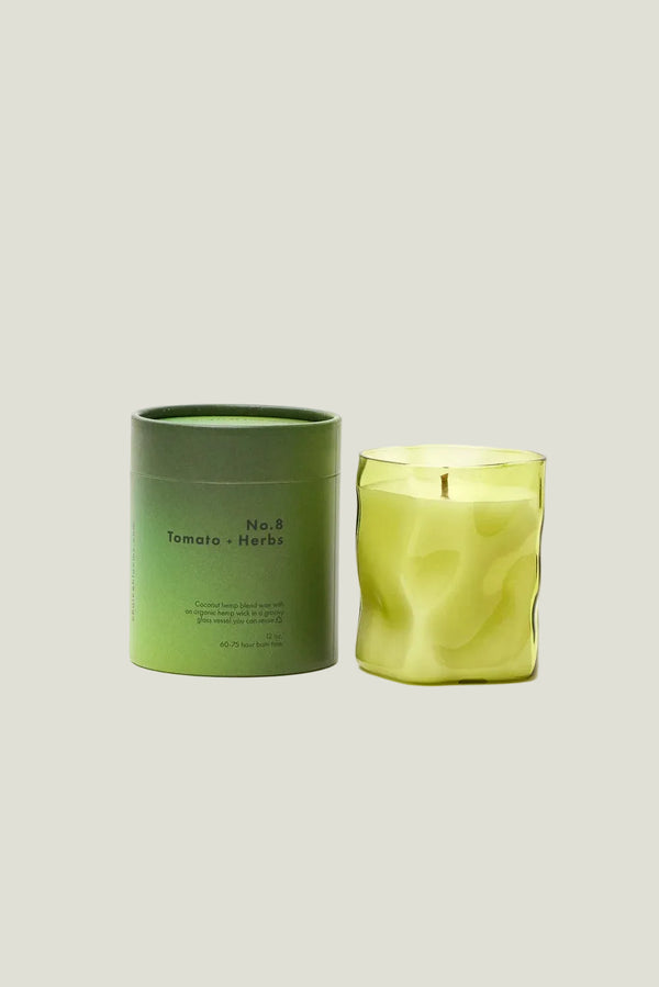 Green candle and packaging on a white background