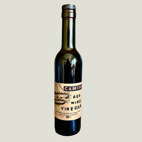 Bottle of Camino Red Wine Vinegar on a textured surface with a neutral background