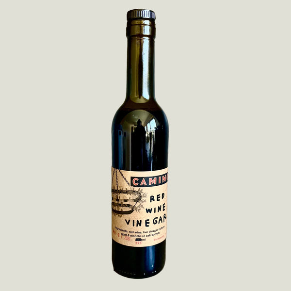 Bottle of Camino Red Wine Vinegar on a textured surface with a neutral background