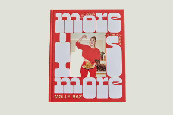 Book titled 'More is More' by Molly Baz on a wooden surface