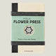 Notebook with 'Field Flower Press' branding on a wooden surface