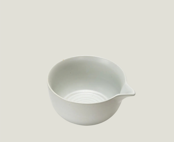 White ceramic pouring bowl on a light gray background