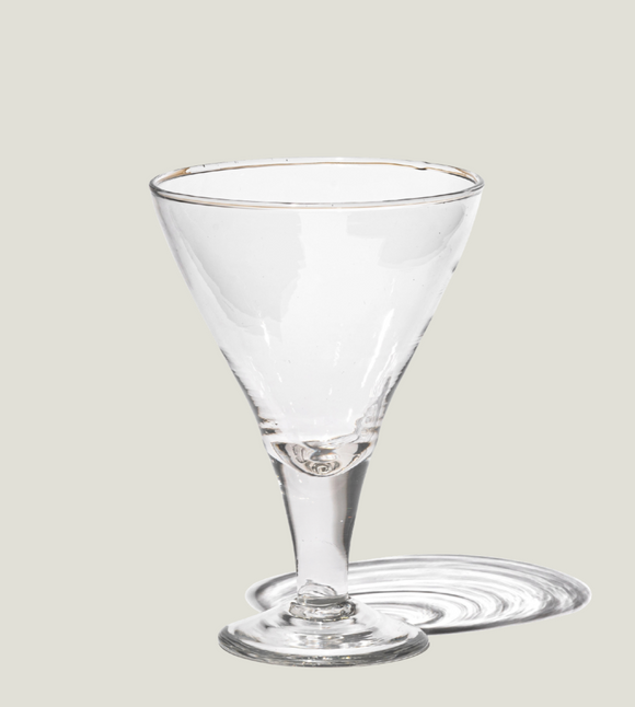 Clear martini glass on a light gray background