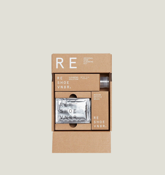 Cardboard packaging of RE SHOE VNR shoe care products on a light gray background