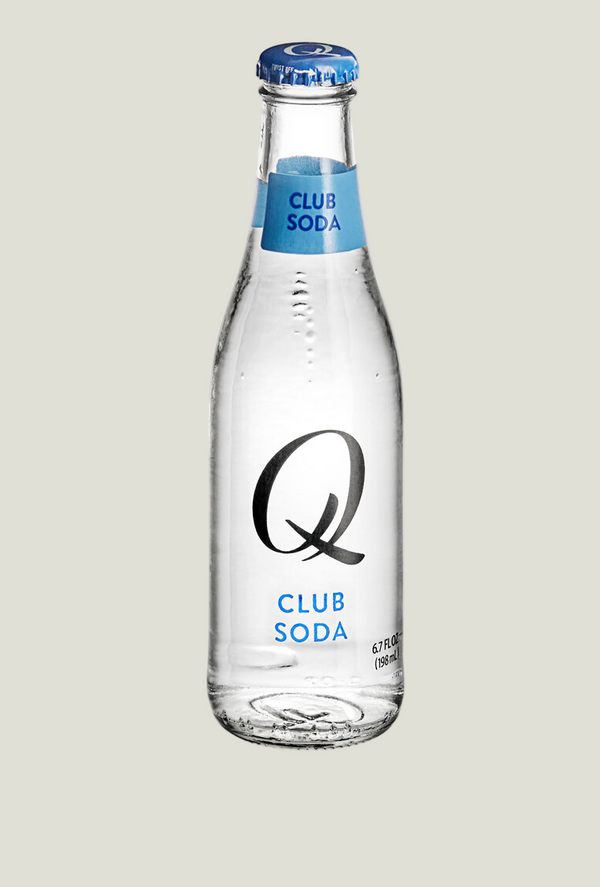 Clear glass bottle of Q Club Soda with a blue label on a white background