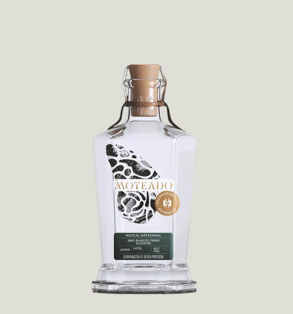 Bottle of Moteado mezcal on a light gray background