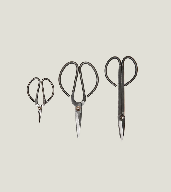 Three pairs of scissors with black handles on a white background