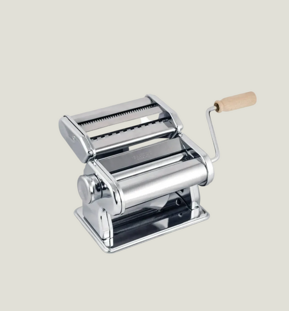 Pasta maker with metal rollers and wooden handle on a light gray background