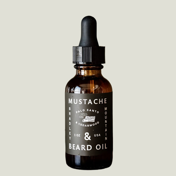 Bottle of Palo Santo and Cedarwood scented Mustache & Beard Oil with black label on white background