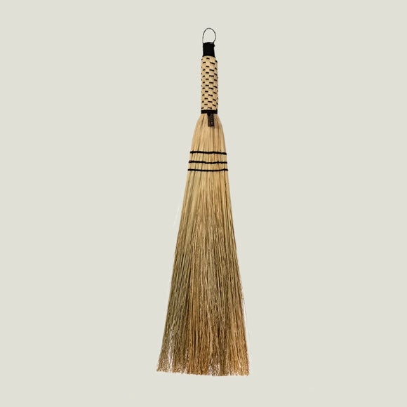 Broom with a woven handle on a white background