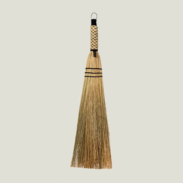 Broom with a woven handle on a white background