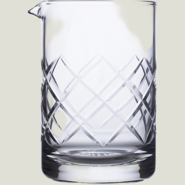 Clear glass pitcher with geometric patterns on a white background