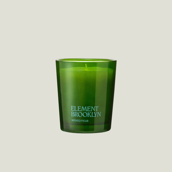 Element Brooklyn Woked Fucus scented candle in a translucent green glass jar, centered on a light off-white background.