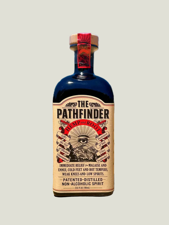 Bottle of 'The Pathfinder' non-alcoholic spirit on a dirt road with a blue sky background.