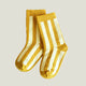Pair of yellow socks with white stripes on a light gray background