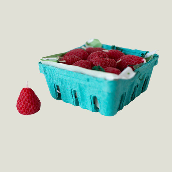 Turquoise berry basket with realistic strawberry candles on an off-white background.